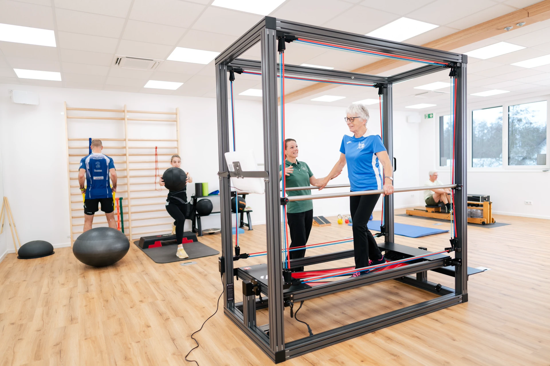 Hüftschmerzen behandeln in Rietberg Frauen und Männer trainieren in einem modernen Fitnessraum mit Geräten und verschiedenen Trainingshilfen.